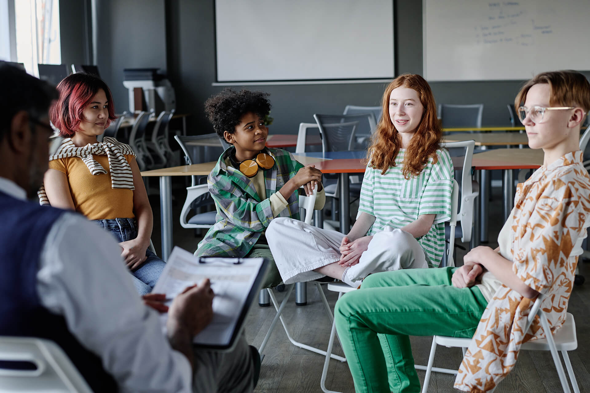 Teen girl speaking about her feelings and emotions during group therapy session at school, copy space