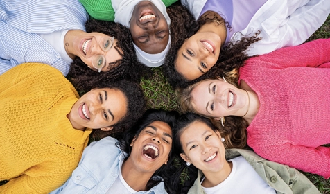 Group of kids smiling while laying down in a circle
